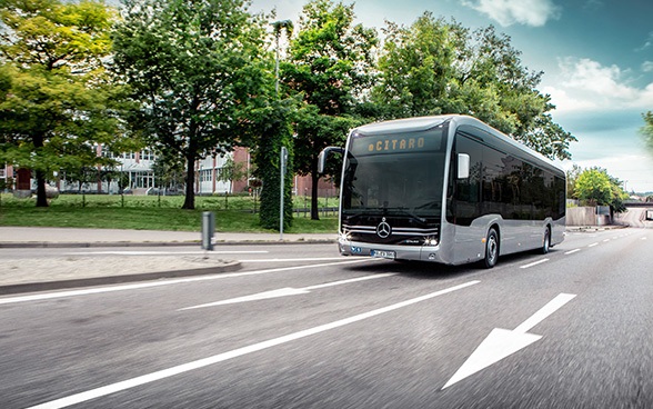 A silver-coloured coach on the road