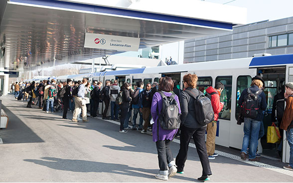 Personen auf dem Perron steigen in die M1 Richtung Lausanne-Flon ein.