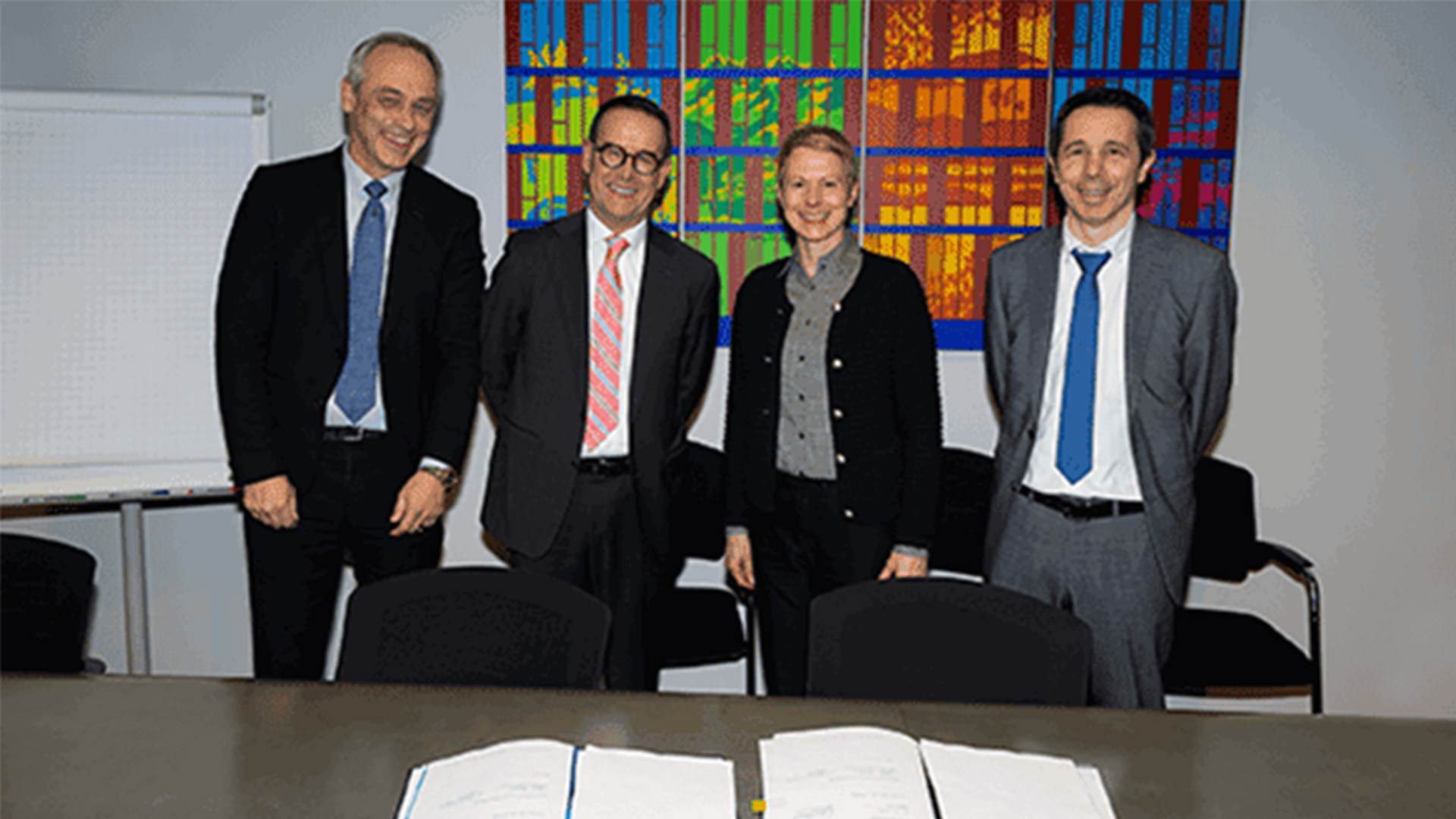 BAV-Direktorin Christa Hostettler und BAV-Vizedirektor Martin von Känel stehen vor einer Wand in einer Reihe mit Paolo Caroni, Verwaltungsratspräsident der FART, und Claudio Blotti, Direktor der FART. Vor ihnen auf dem Tisch liegt das Dossier mit der Leistungsvereinbarung.