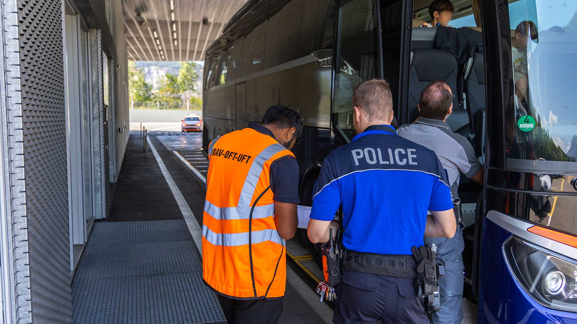 Ein Mitarbeiter des BAV und ein Kantonspolizist kontrollieren einen Reisecar