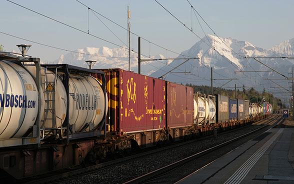 Un train de marchandises dans le crépuscule, avec en toile de fond les Alpes bernoises, le Niesen et le Blüemlisalp.
