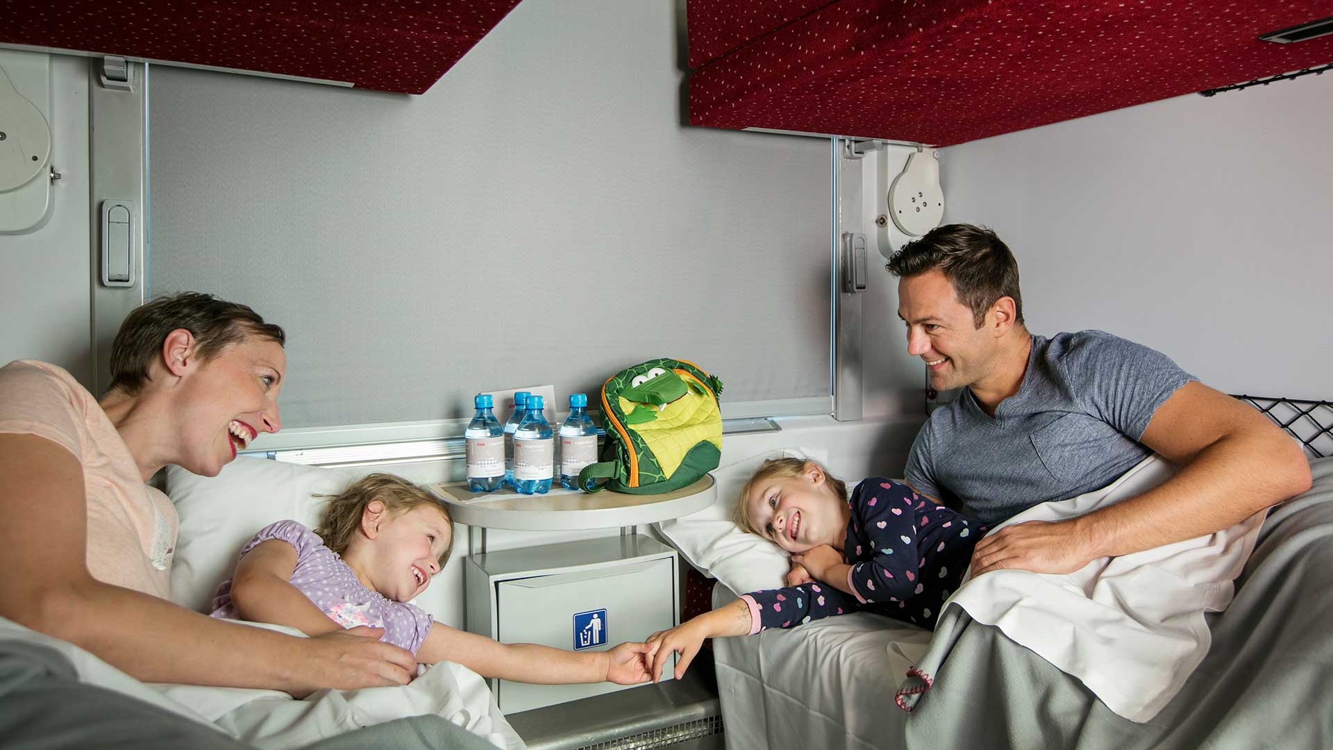 Famille avec deux jeunes enfants dans un train de nuit.