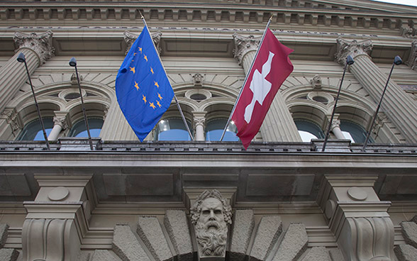 Façade du Palais fédéral ornée des drapeaux de la Suisse et de l’UE