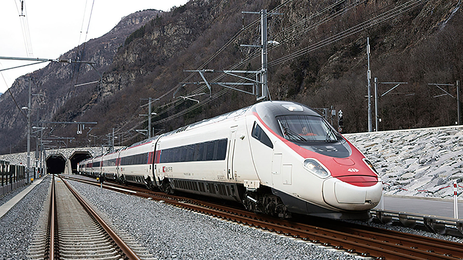 Un treno passeggeri delle FFS lascia la Galleria di Base del San Gottardo al portale sud.