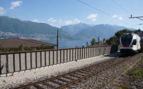 Un treno corre lungo una parete antirumore a Gerra