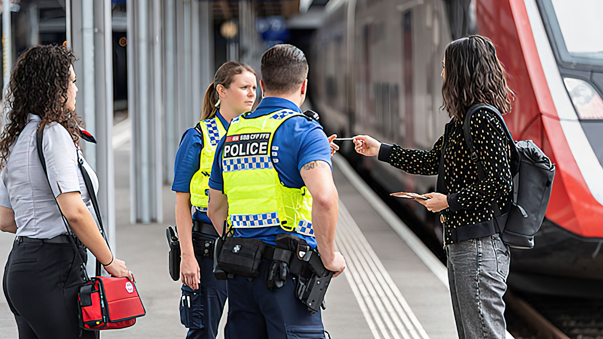 Un utente discute con due agenti in uniforme della polizia dei trasporti.